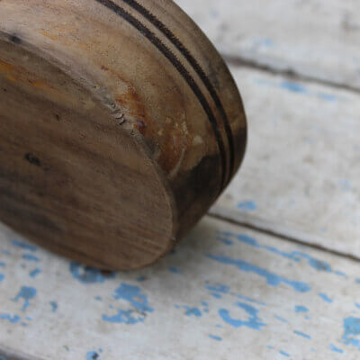 Fragmento de un mortero de madera sobre maderas pintada con blanco y azul