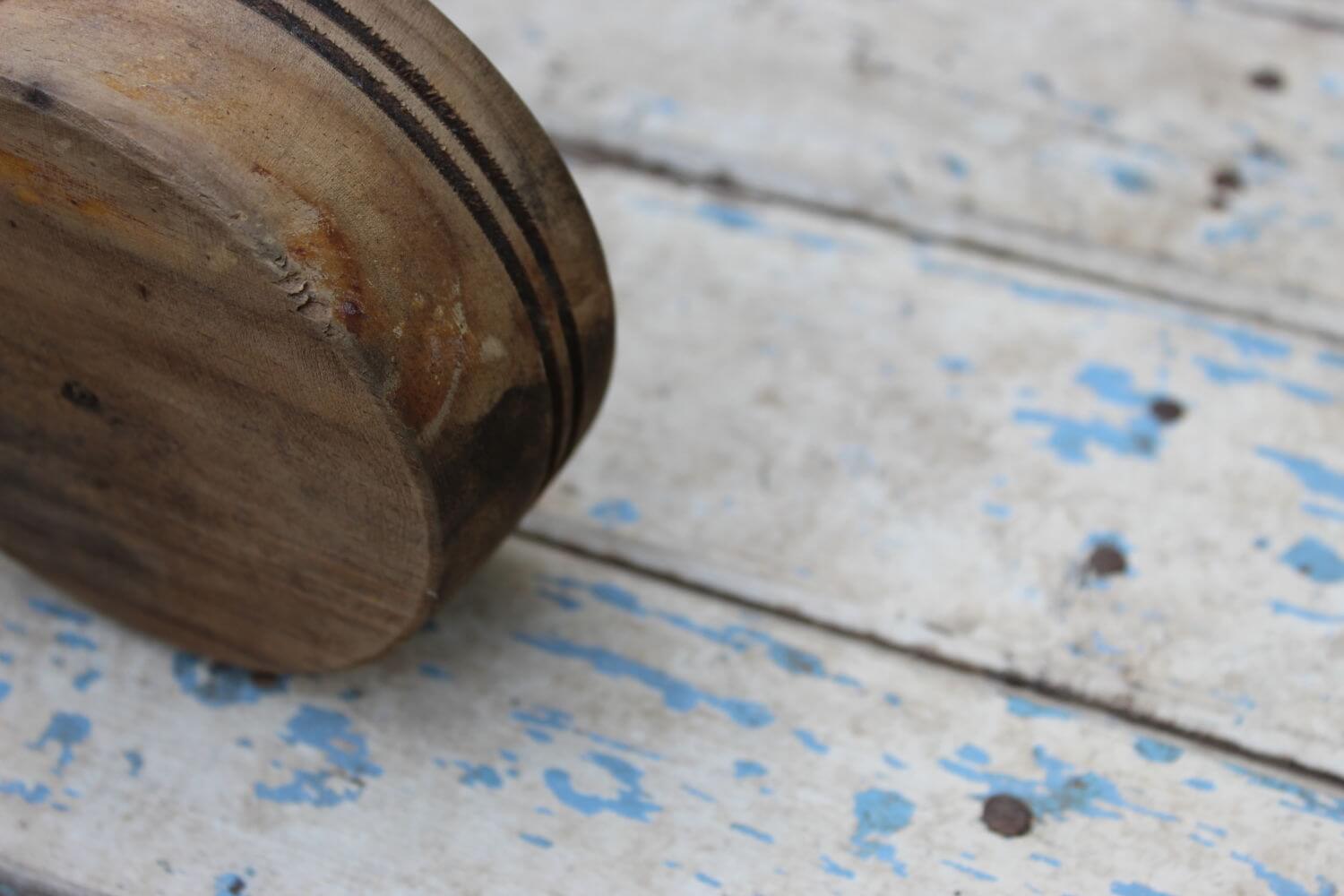 Mortero de madera sobre una madera pintada blanca con manchas azules