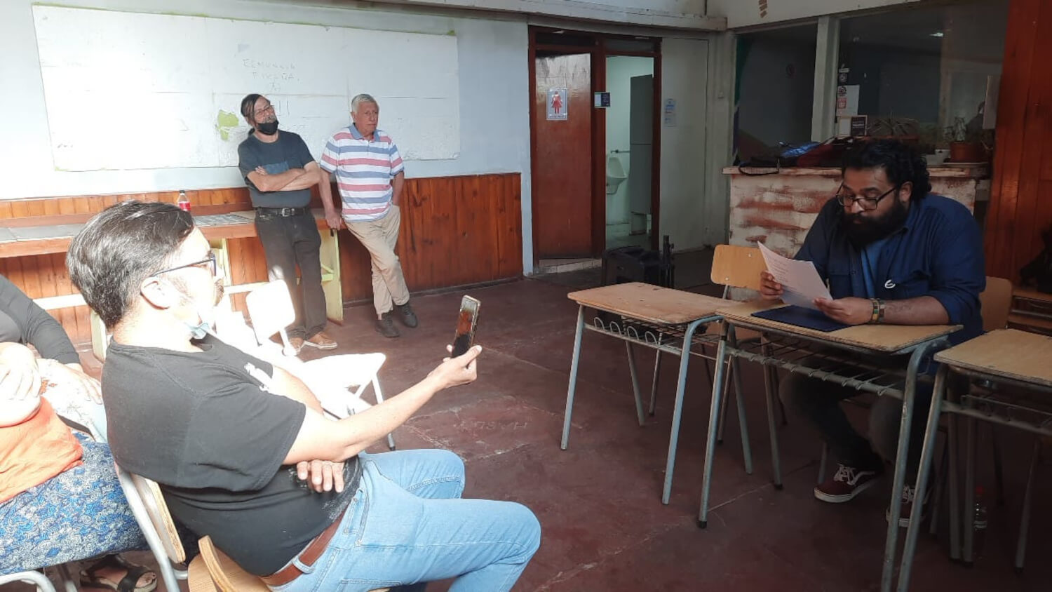 Personas sentadas escuchando una presentación al interior de una sala